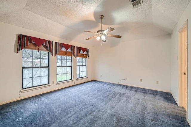 spare room with carpet flooring, ceiling fan, a raised ceiling, a textured ceiling, and lofted ceiling