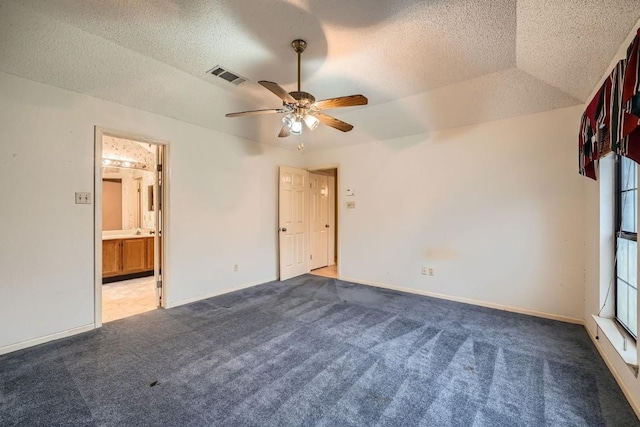 interior space with light colored carpet, a raised ceiling, ceiling fan, and ensuite bathroom