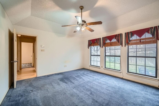 spare room featuring carpet, ceiling fan, and vaulted ceiling