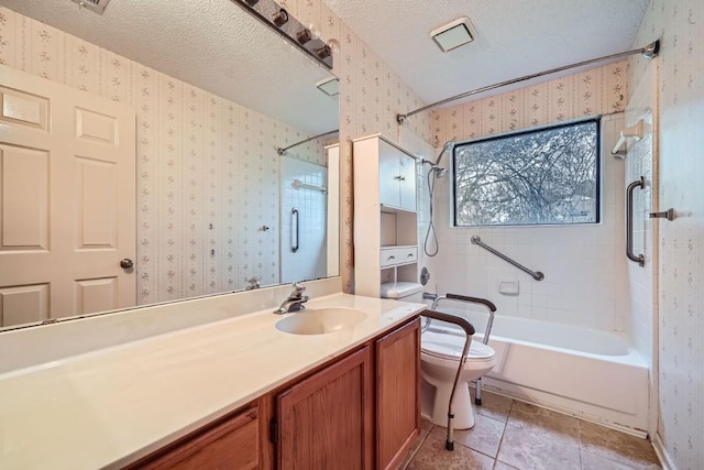 full bathroom with vanity, a textured ceiling, tile patterned flooring, toilet, and tiled shower / bath