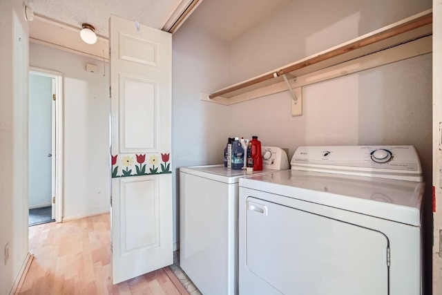 laundry room with independent washer and dryer and light wood-type flooring