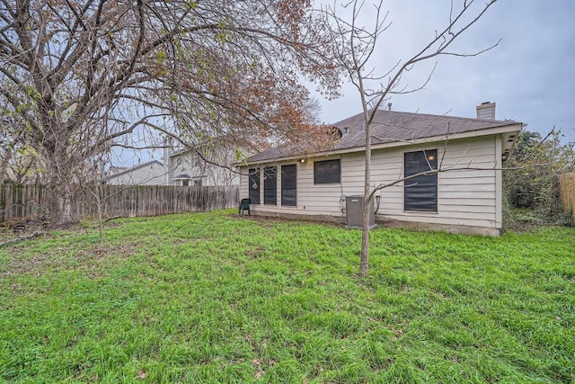 rear view of house featuring a yard and cooling unit