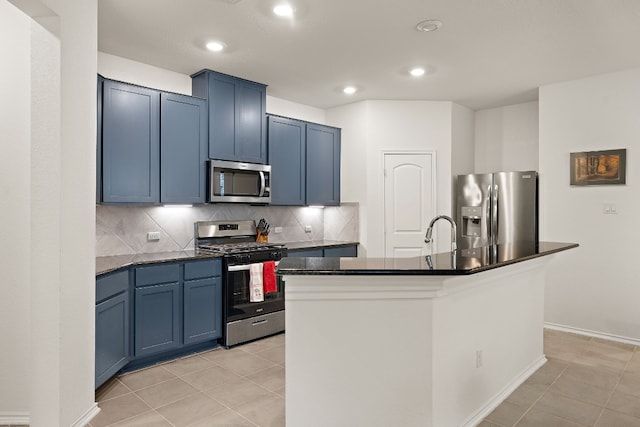 kitchen featuring a center island with sink, light tile patterned floors, stainless steel appliances, and blue cabinets