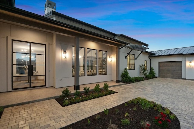 exterior entry at dusk featuring a garage