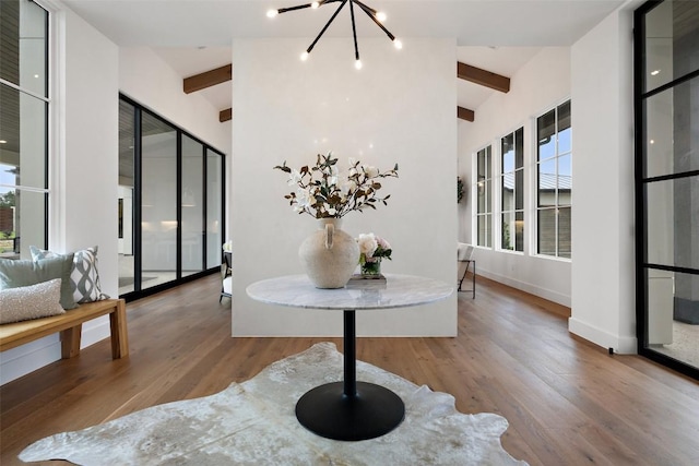 interior space with hardwood / wood-style flooring, a notable chandelier, and vaulted ceiling