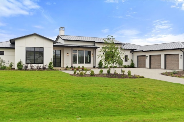 modern farmhouse with metal roof, decorative driveway, a standing seam roof, and a front lawn