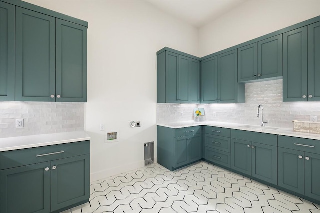 kitchen featuring green cabinets, light countertops, and a sink