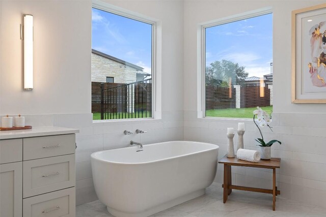 bathroom featuring a tub to relax in and tile walls