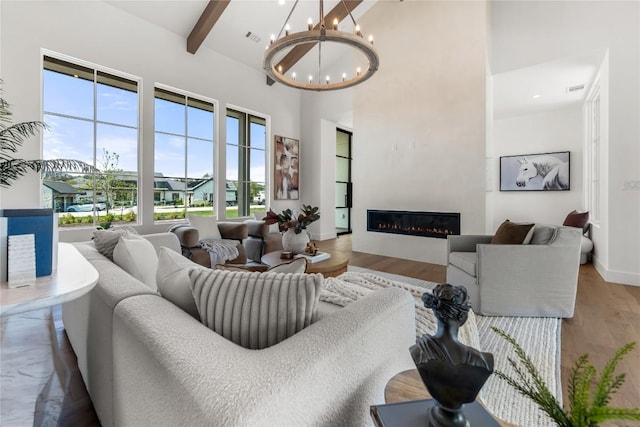 17212 Morning Grove Ln, Austin, TX 78738 - living area with a high ceiling, a chandelier, wood finished floors, beam ceiling, and a glass covered fireplace