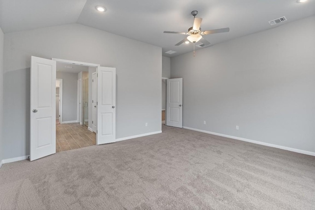 unfurnished bedroom with ceiling fan, light colored carpet, and vaulted ceiling