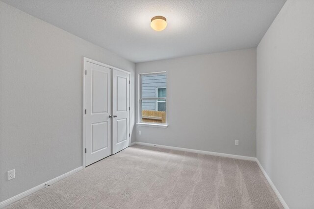 carpeted spare room with a textured ceiling