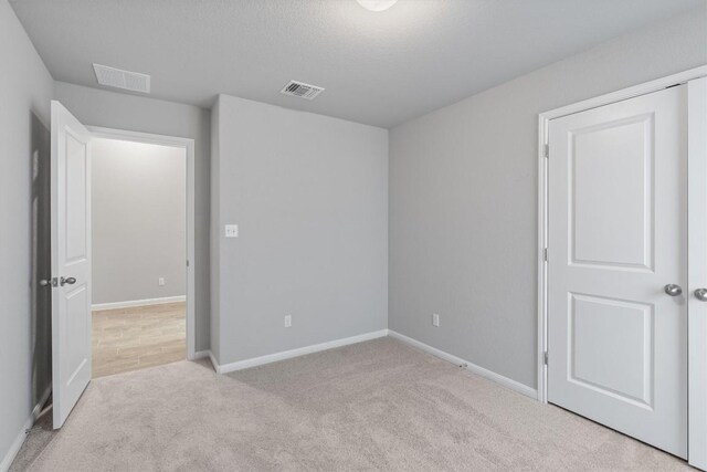 carpeted spare room with a textured ceiling