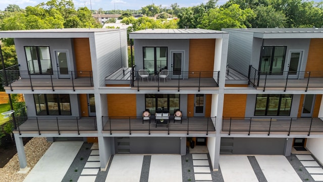 rear view of property with a balcony and a garage