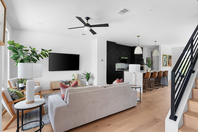 living room featuring light hardwood / wood-style floors and ceiling fan