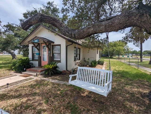 bungalow-style house featuring cooling unit and a front lawn