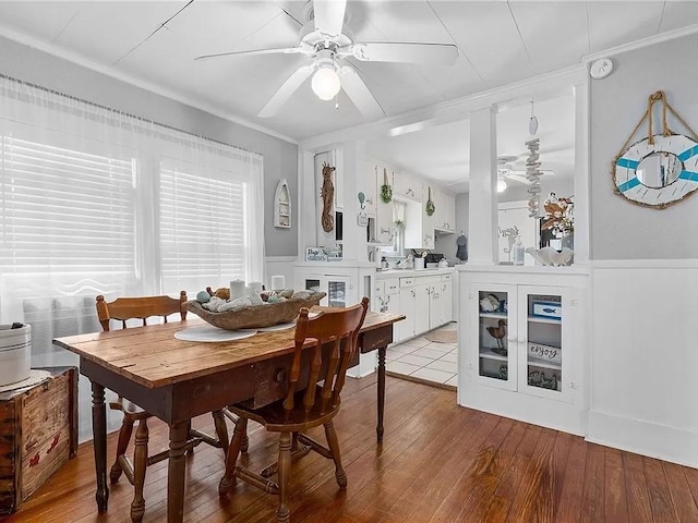 dining area featuring light wood-type flooring, ceiling fan, and ornamental molding