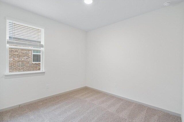 unfurnished room with carpet flooring and baseboards