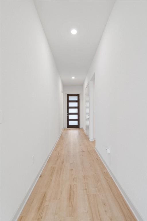 hall with baseboards, light wood-style flooring, and recessed lighting