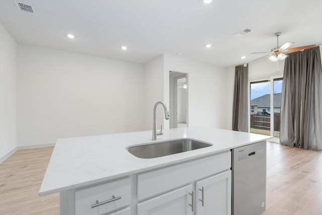 kitchen with visible vents, a kitchen island with sink, a sink, stainless steel dishwasher, and light wood-style floors