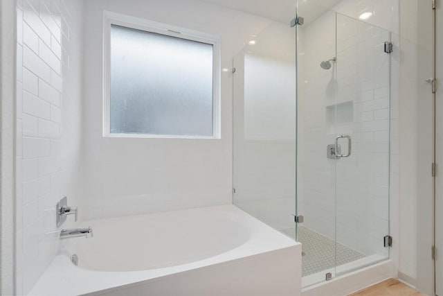 bathroom featuring a garden tub and a shower stall