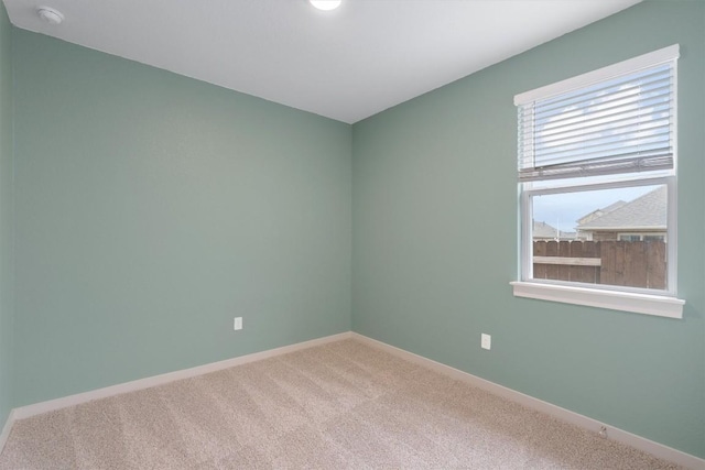unfurnished room featuring carpet flooring and baseboards