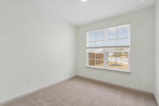 empty room featuring baseboards and carpet flooring