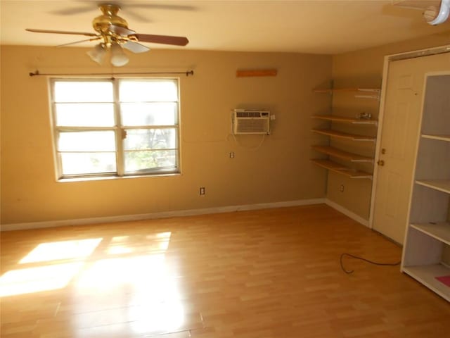 spare room with a wealth of natural light, light hardwood / wood-style flooring, a wall mounted AC, and ceiling fan