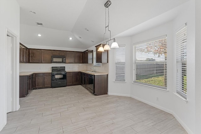 kitchen with backsplash, dark brown cabinetry, sink, black appliances, and decorative light fixtures