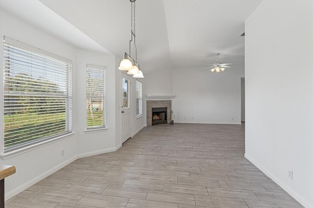 unfurnished living room with a tile fireplace, ceiling fan, and lofted ceiling