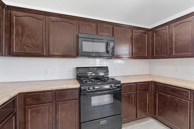 kitchen with light tile patterned flooring, dark brown cabinetry, tasteful backsplash, and black appliances