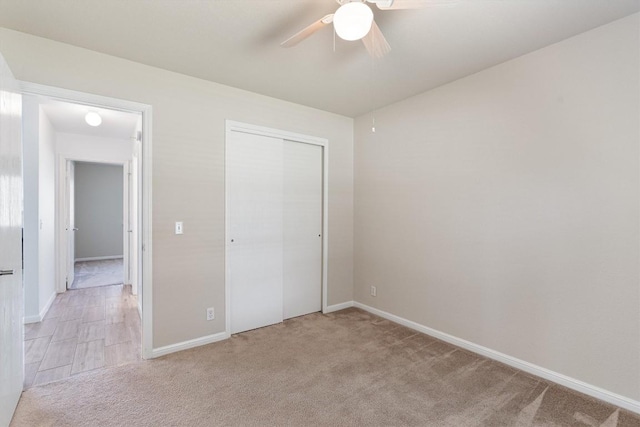 unfurnished bedroom featuring ceiling fan, light carpet, and a closet