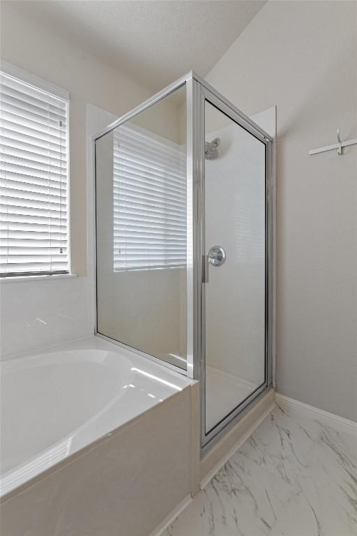 bathroom featuring shower with separate bathtub