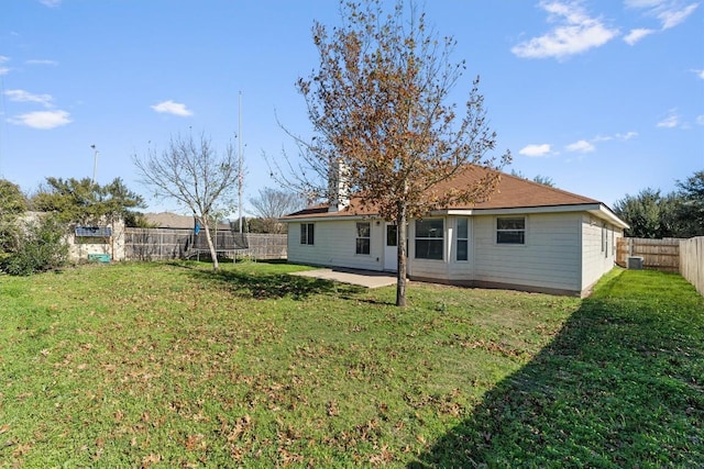 back of property with a lawn, a patio area, and central AC unit