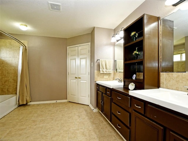 bathroom featuring vanity, decorative backsplash, and shower / bath combo with shower curtain