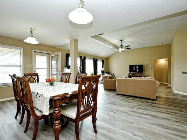 dining area featuring ceiling fan, light wood-type flooring, and vaulted ceiling