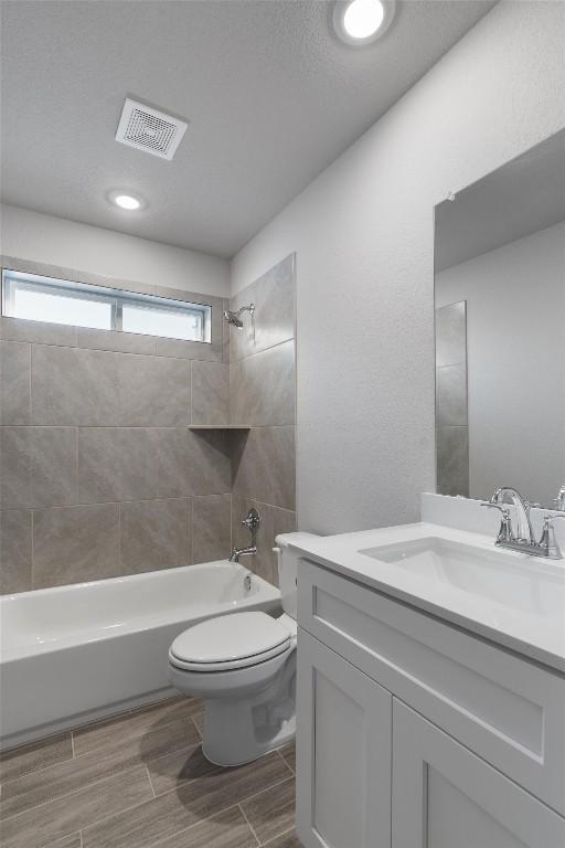 full bathroom featuring vanity, toilet, and tiled shower / bath