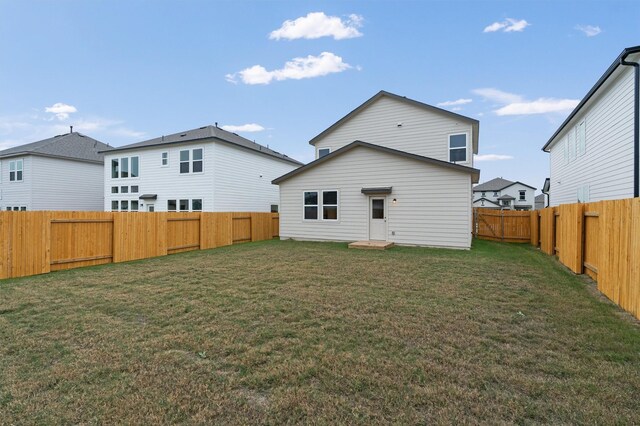 rear view of house featuring a yard