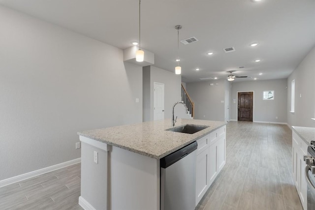 kitchen featuring stainless steel appliances, sink, pendant lighting, a center island with sink, and white cabinets