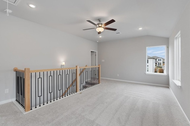 carpeted spare room with ceiling fan and vaulted ceiling