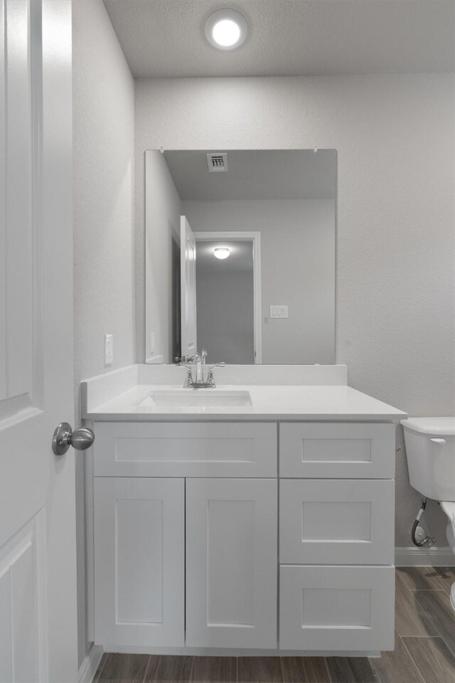 bathroom featuring vanity and toilet