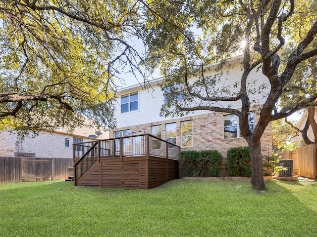 rear view of property with a lawn and a wooden deck