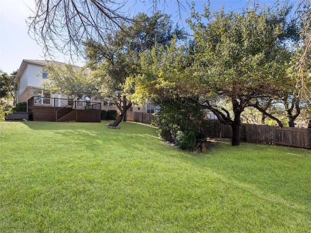 view of yard with a wooden deck, stairs, and a fenced backyard