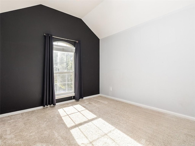 carpeted empty room featuring vaulted ceiling