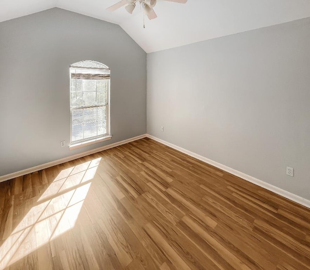 unfurnished room featuring a ceiling fan, lofted ceiling, wood finished floors, and baseboards