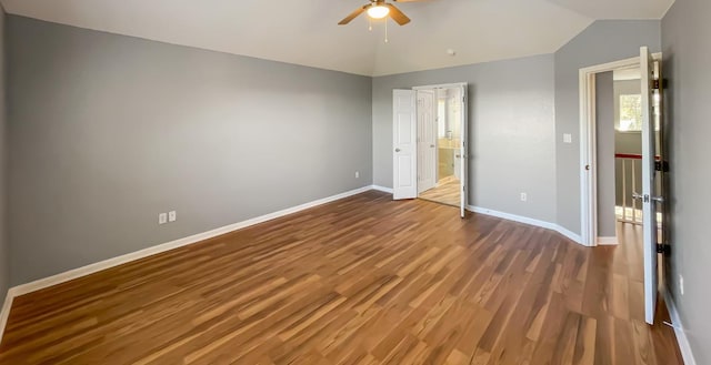 unfurnished bedroom featuring a ceiling fan, vaulted ceiling, wood finished floors, and baseboards