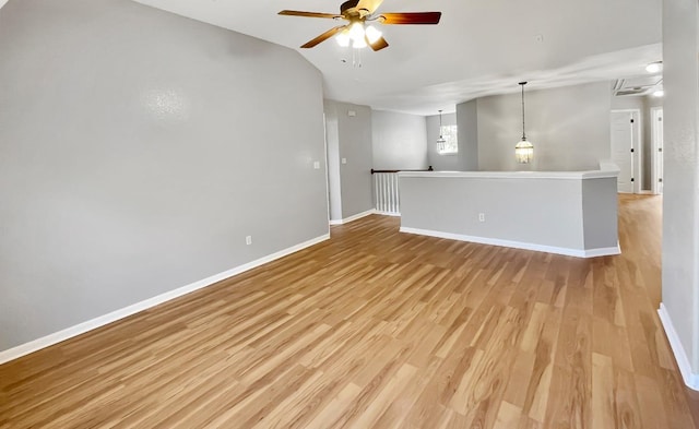 spare room with light wood-type flooring, baseboards, and a ceiling fan