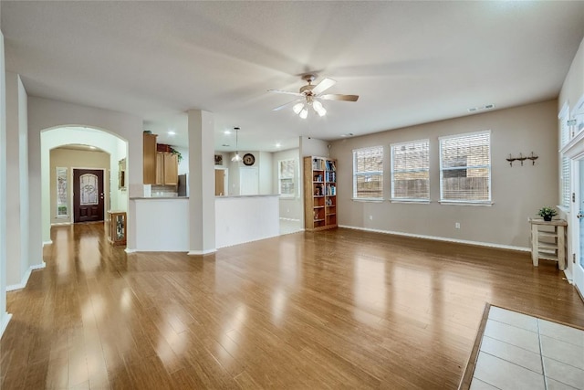 unfurnished living room featuring ceiling fan and light wood-type flooring