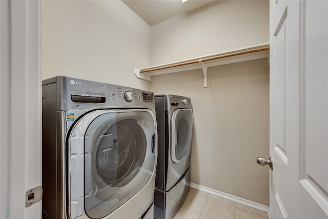 washroom featuring light tile patterned floors and washer and clothes dryer