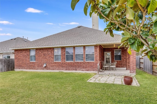 rear view of house with a lawn and a patio area