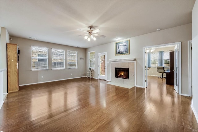 unfurnished living room featuring ceiling fan, a fireplace, and hardwood / wood-style floors